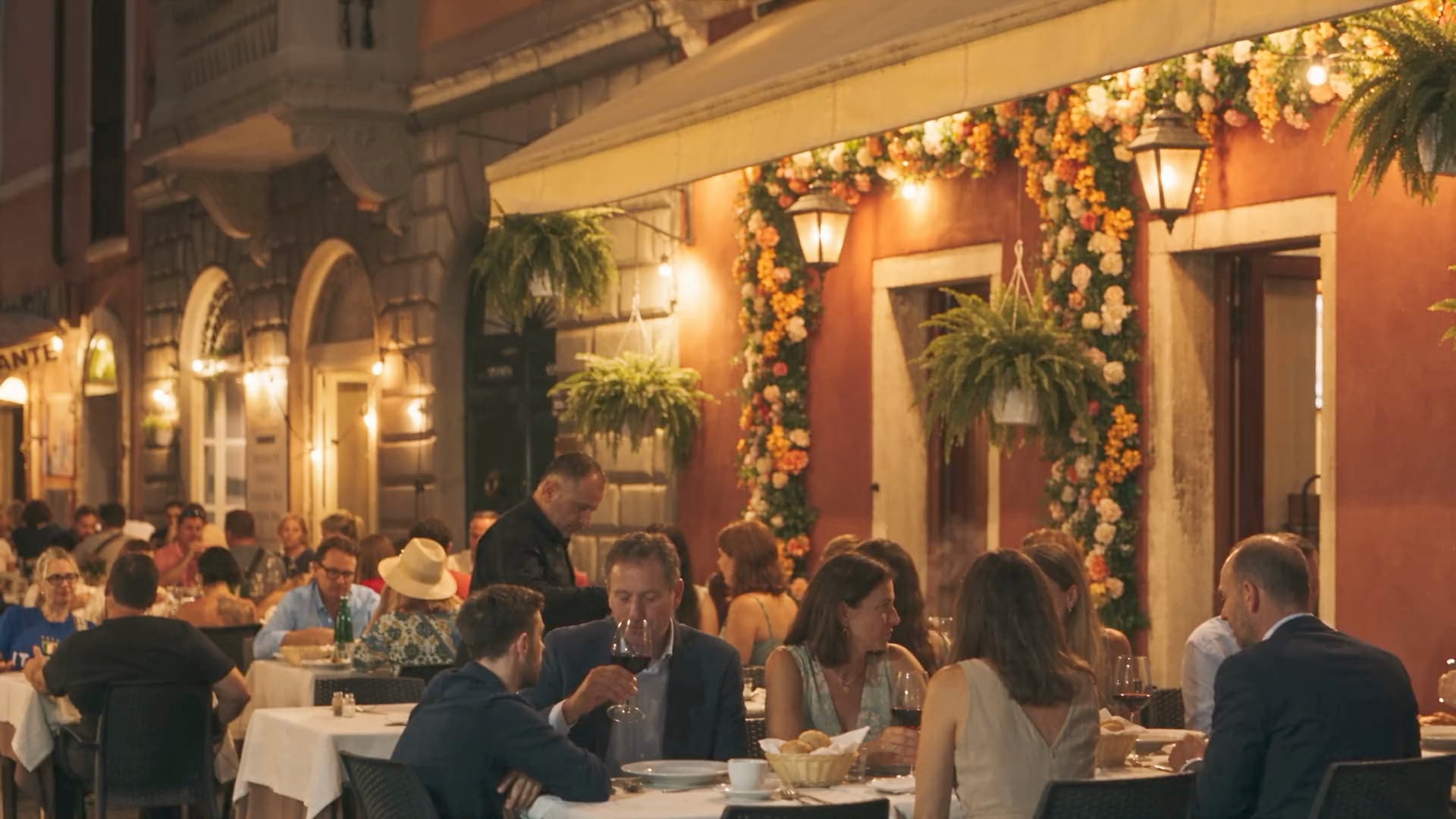 A full pavement terrace outside a bistro after dark